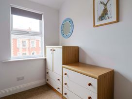 A bedroom with a drawer unit and a mirror at 4 Peaslands Road Sidmouth
