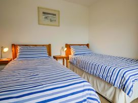 A bedroom with two single beds and a painting at 4 Peaslands Road Sidmouth