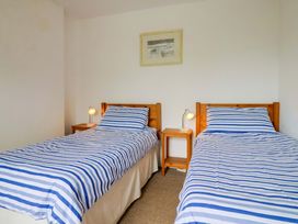 A bedroom with two beds and side tables at 4 Peaslands Road in Sidmouth