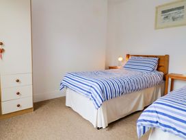 A bedroom with two beds and a wardrobe at 4 Peaslands Road Sidmouth