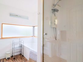 A bathroom featuring a bathtub and shower at 4 Peaslands Road Sidmouth