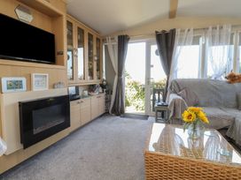 A living room with a television and sofa at 33 Pendle View in Clitheroe