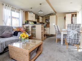 A living room with a couch, table and chairs at 33 Pendle View in Clitheroe