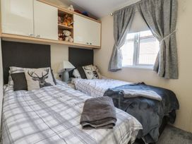 A bedroom with two beds and a window at 33 Pendle View in Clitheroe