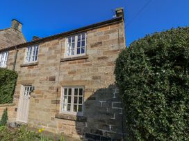 A stone house with windows and door at Holly Cottage in Whitby