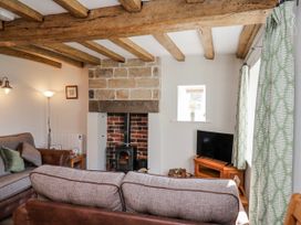 A living room with a fireplace and sofa at Holly Cottage in Whitby