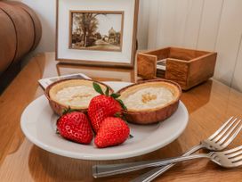 A plate with tarts and strawberries on a table at Holly Cottage in Whitby