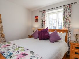 A bedroom with a bed and nightstand at Holly Cottage in Whitby