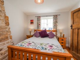 A bedroom with a bed and bedside table at Holly Cottage in Whitby