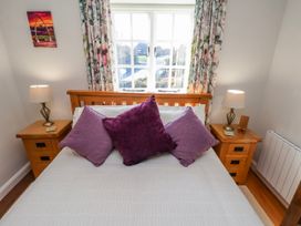 A bedroom with a bed and bedside tables at Holly Cottage in Whitby