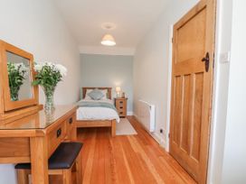 A bedroom with a bed and wooden furniture at Holly Cottage in Whitby