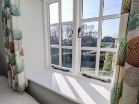A bedroom window with curtains and view at Holly Cottage in Whitby
