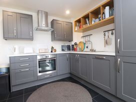 A kitchen with cabinets and appliances at 7 Sisial Y Mor Rhosneigr