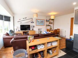 A living room with a television and dining table at 7 Sisial Y Mor in Rhosneigr
