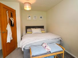 A bedroom with a bed and a bedside table at 7 Sisial Y Mor in Rhosneigr