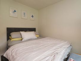 A bedroom with a bed and wall art at 7 Sisial Y Mor Rhosneigr