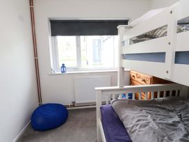 A bedroom with bunk bed and chest of drawers at 7 Sisial Y Mor in Rhosneigr