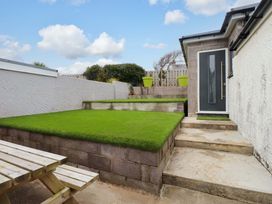 A garden with grass steps and a door at 7 Sisial Y Mor Rhosneigr