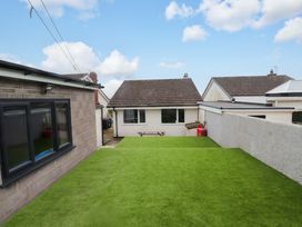 A garden with artificial grass and a picnic table at 7 Sisial Y Mor Rhosneigr