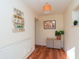A hallway with wall art, a table and a plant at Marina House in Whitby