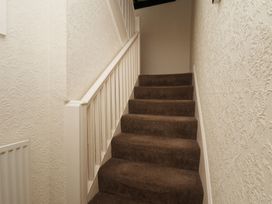 A staircase with carpet and handrail at Marina House in Whitby