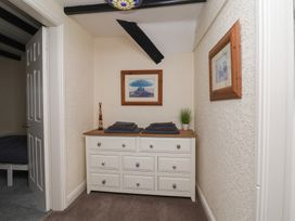 A hallway with a dresser and towels at Marina House in Whitby