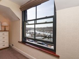 A bedroom with a window overlooking a marina at Marina House in Whitby