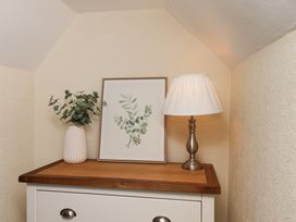 A table with a plant, picture, and lamp at Marina House in Whitby