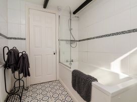A bathroom featuring a bathtub, showerhead, and towel rack at Marina House in Whitby