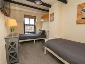 A bedroom with two beds and a window at Marina House in Whitby