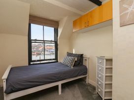 A bedroom with a bed and dresser at Marina House in Whitby