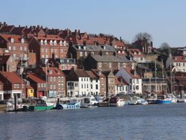 A waterfront view with houses and boats at Marina House in Whitby