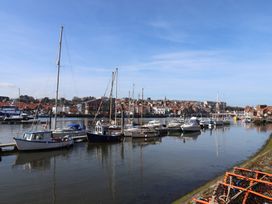 A view of boats in a harbor with a city in the background at Marina House in Whitby