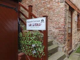 A staircase leading to a door with a sign for Bishop's Cottage in Whitby