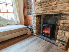 A living room with a fireplace and a sofa at Bishop's Cottage in Whitby