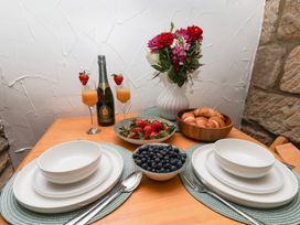 A dining table set with champagne, fruit, and pastries at Bishop's Cottage in Whitby