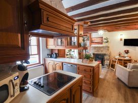 A kitchen with wooden cabinets and appliances at Bishop's Cottage in Whitby