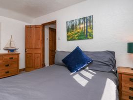 A bedroom with a bed and wooden furniture at Bishop's Cottage in Whitby