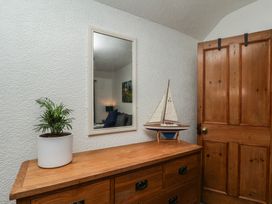 A hallway with a wooden dresser and a mirror at Bishop's Cottage in Whitby