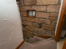 A staircase with stone walls and a window at Bishop's Cottage in Whitby