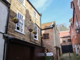 Exterior view of buildings with flower baskets at Bishop's Cottage in Whitby