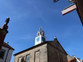 A clock tower building with a coffee and pastries sign at Bishop's Cottage Whitby