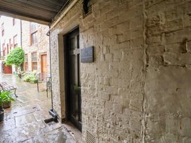 An outdoor corridor with a door and brick wall at G's Loft in Whitby