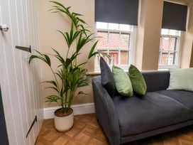 A living room with a plant and couch at G's Loft in Whitby