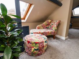 A snug with an armchair and ottoman at G's Loft in Whitby