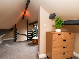 An attic with a chest of drawers and a plant at G's Loft in Whitby