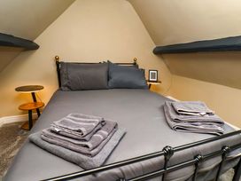 A bedroom with a bed and towels arranged at G's Loft in Whitby