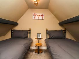 A bedroom with two beds and a small table at G's Loft in Whitby