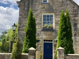 A building with a blue door and flower box at Groves Hall Garden Apartment Whitby