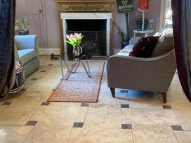 A living room with a sofa, coffee table, and fireplace at Groves Hall Garden Apartment Whitby